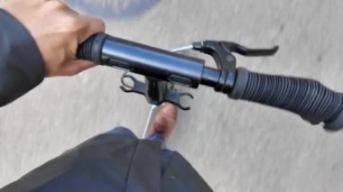 Şehrin caddesinde elektrikli scooter kullanan bir adamın kısmi üst görüntüsü