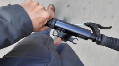 Şehrin caddesinde elektrikli scooter kullanan bir adamın kısmi üst görüntüsü