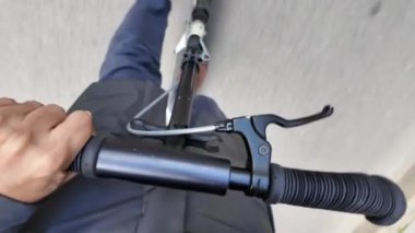 Şehrin caddesinde elektrikli scooter kullanan bir adamın kısmi üst görüntüsü