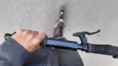 Şehrin caddesinde elektrikli scooter kullanan bir adamın kısmi üst görüntüsü