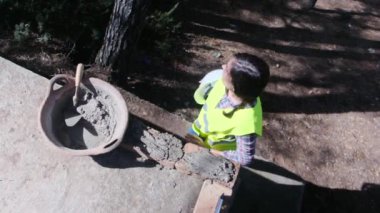 Üniformalı ve kasklı bir kadın işçi güneşli bir günde inşaatta mola veriyor.