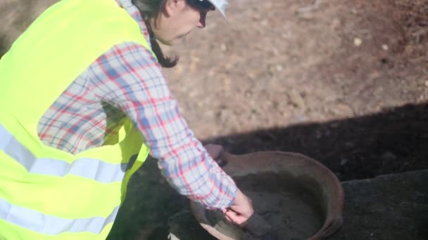 Vrouwelijke Werknemer Draagt Uniform Helm Mengt Cement Kom Bouwplaats Zonnige — Stockvideo
