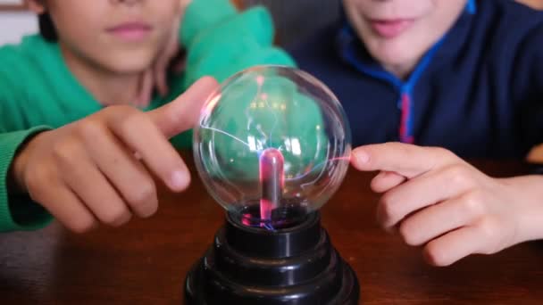 Μικρά Αγόρια Σπουδάζουν Μπάλα Πλάσματος Αστραπή Στο Τραπέζι — Αρχείο Βίντεο