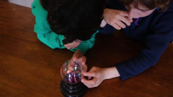 Μικρά Αγόρια Σπουδάζουν Μπάλα Πλάσματος Αστραπή Στο Τραπέζι — Αρχείο Βίντεο