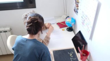 Annesinin, oğlunun evde matematik ödevi yapmasına yardım ettiği en iyi manzara.