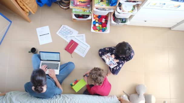 Widok Kobiety Pracującej Laptopie Jej Synów Bawiących Się Podłodze Domu — Wideo stockowe