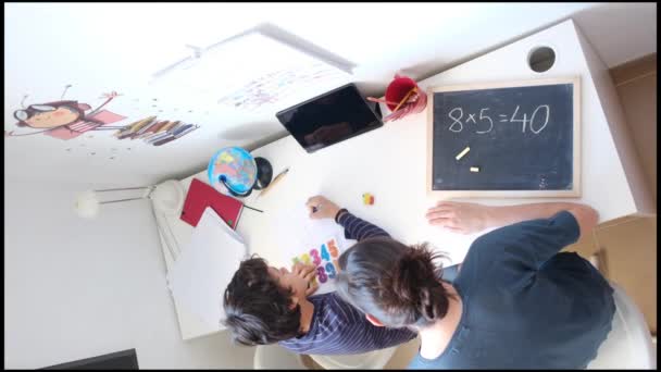 Widok Matki Pomagającej Synowi Odrabiać Lekcje Matematyki Przy Stole Domu — Wideo stockowe