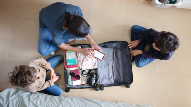 Top View Woman Using Smartphone While Collecting Things Suitcase Sons — Stock Video