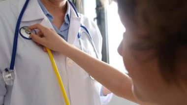 Klinikte steteskopla kadın doktoru muayene eden çocuk hasta.