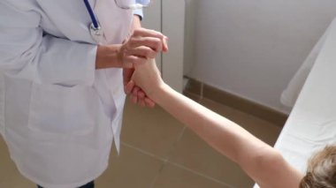 Klinikte erkek hastanın bacağını muayene eden kadın doktor.