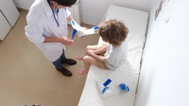 Klinikte kırık bir çocuğun bacağını takmak için kadın doktorların ortopedi ameliyatına hazırlandığını gördüm.