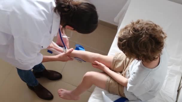 Női Orvos Vesz Fel Derotációs Orthosis Törés Fiú Lábát Klinikán — Stock videók