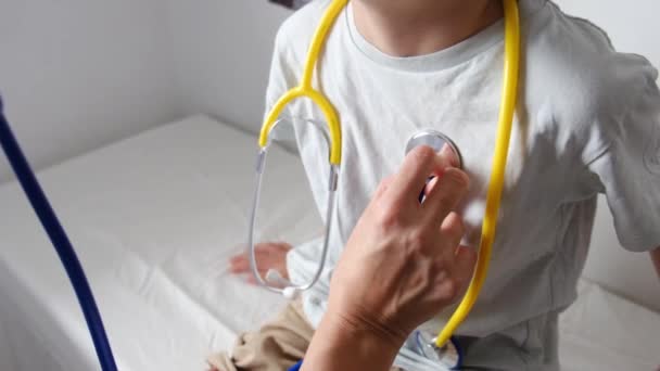 Kvinnlig Läkare Kontrollerar Hjärtslag Hos Pojke Patient Med Stetoskop Kliniken Royaltyfri Stockfilm