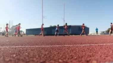 Stadyumdaki spor pistlerinde spor yapan bulanık insanların alt görünümü