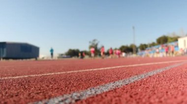 Stadyumdaki spor pistlerinde spor yapan bulanık insanların alt görünümü