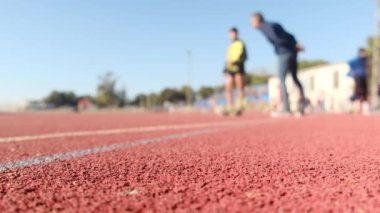 Stadyumdaki spor pistlerinde spor yapan bulanık insanların alt görünümü