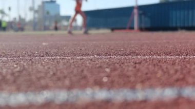 Stadyumdaki spor pistlerinde spor yapan bulanık insanların alt görünümü