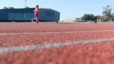 Stadyumdaki spor pistlerinde spor yapan bulanık insanların alt görünümü