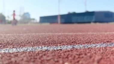 Stadyumdaki spor pistlerinde spor yapan bulanık insanların alt görünümü