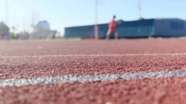 Stadyumdaki spor pistlerinde spor yapan bulanık insanların alt görünümü