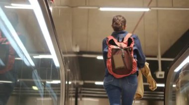 Metroda sırt çantalı genç bir kadın var..