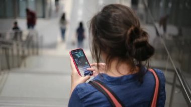 Metro istasyonunda akıllı telefon kullanan genç bir kadın. 