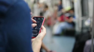 Metroda Smartphone kullanan genç kadın 