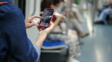 Metroda Smartphone kullanan genç kadın 