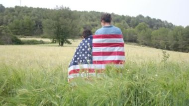 ABD bayrağıyla anne ve oğlunun arka görüntüsü. 4 Temmuz Bağımsızlık Günü.