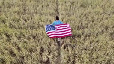 Amerika bayrağıyla sahada koşan bir kadının arka plan görüntüsü. 4 Temmuz Bağımsızlık Günü.