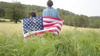 ABD bayrağıyla anne ve oğlunun arka görüntüsü. 4 Temmuz Bağımsızlık Günü.