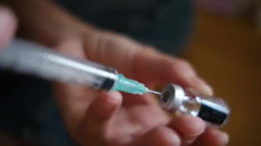 Kadın şişeden şırıngayla ilaç alıyor.. 