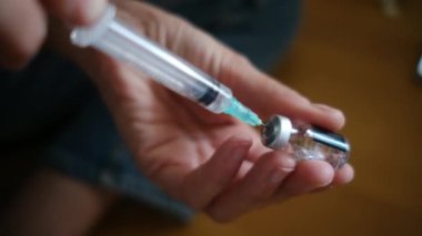 Kadın şişeden şırıngayla ilaç alıyor.. 