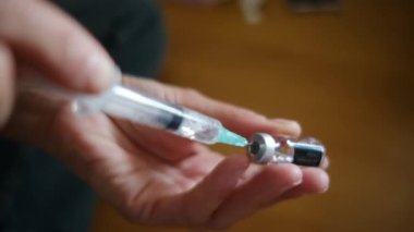 Kadın şişeden şırıngayla ilaç alıyor.. 