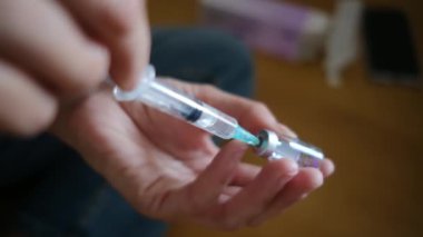 Kadın şişeden şırıngayla ilaç alıyor.. 