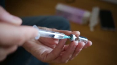 Kadın şişeden şırıngayla ilaç alıyor.. 