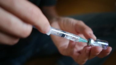 Kadın şişeden şırıngayla ilaç alıyor.. 