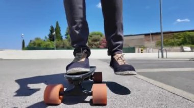 Kaykaycının ayakları şehrin caddesinde Mini Longboard kruvazörüyle kaykay yapıyor. 