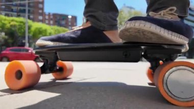 Kaykaycının ayakları şehrin caddesinde Mini Longboard kruvazörüyle kaykay yapıyor. 