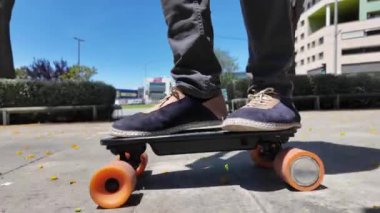 Kaykaycının ayakları şehrin caddesinde Mini Longboard kruvazörüyle kaykay yapıyor. 