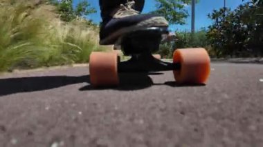 Kaykaycının ayakları şehrin caddesinde Mini Longboard kruvazörüyle kaykay yapıyor. 