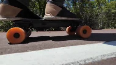 Kaykaycının ayakları şehrin caddesinde Mini Longboard kruvazörüyle kaykay yapıyor. 