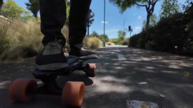 Kaykaycının ayakları şehrin caddesinde Mini Longboard kruvazörüyle kaykay yapıyor. 