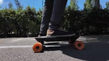 Kaykaycının ayakları şehrin caddesinde Mini Longboard kruvazörüyle kaykay yapıyor. 