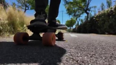 Kaykaycının ayakları şehrin caddesinde Mini Longboard kruvazörüyle kaykay yapıyor. 