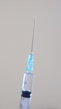 Kadın eli şırıngayı tutuyor, yakın plan.