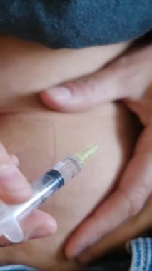 Doğurganlık tedavisi için karnına progesteron enjekte eden kadın, destekli üreme, jinekoloji ve üremeye odaklanıyor.