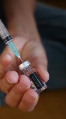 Kadın şişeden şırıngayla ilaç alıyor.. 