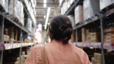 Hırdavatçıda yürüyen genç bir kadının arka plan görüntüsü 