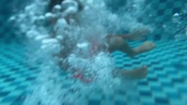 Havuza atlayan bir çocuk, 8 yaşındaki çocuklar için yaz tatili eğlencesi. Su sporları ve sağlıklı yaşam ile açık havada aktif yaşam tarzı